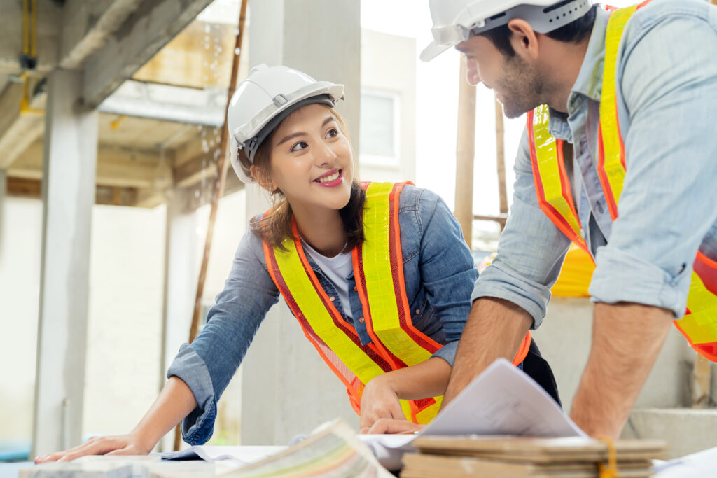 young asian engineers caucasian engineer colleagues site inspector discuss together using notebook computer paper blueprint building construction sitehome renovation ideas concept